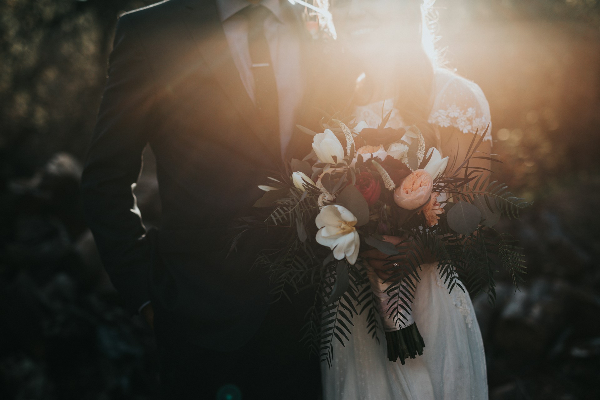 couple with bouquet in sun ray