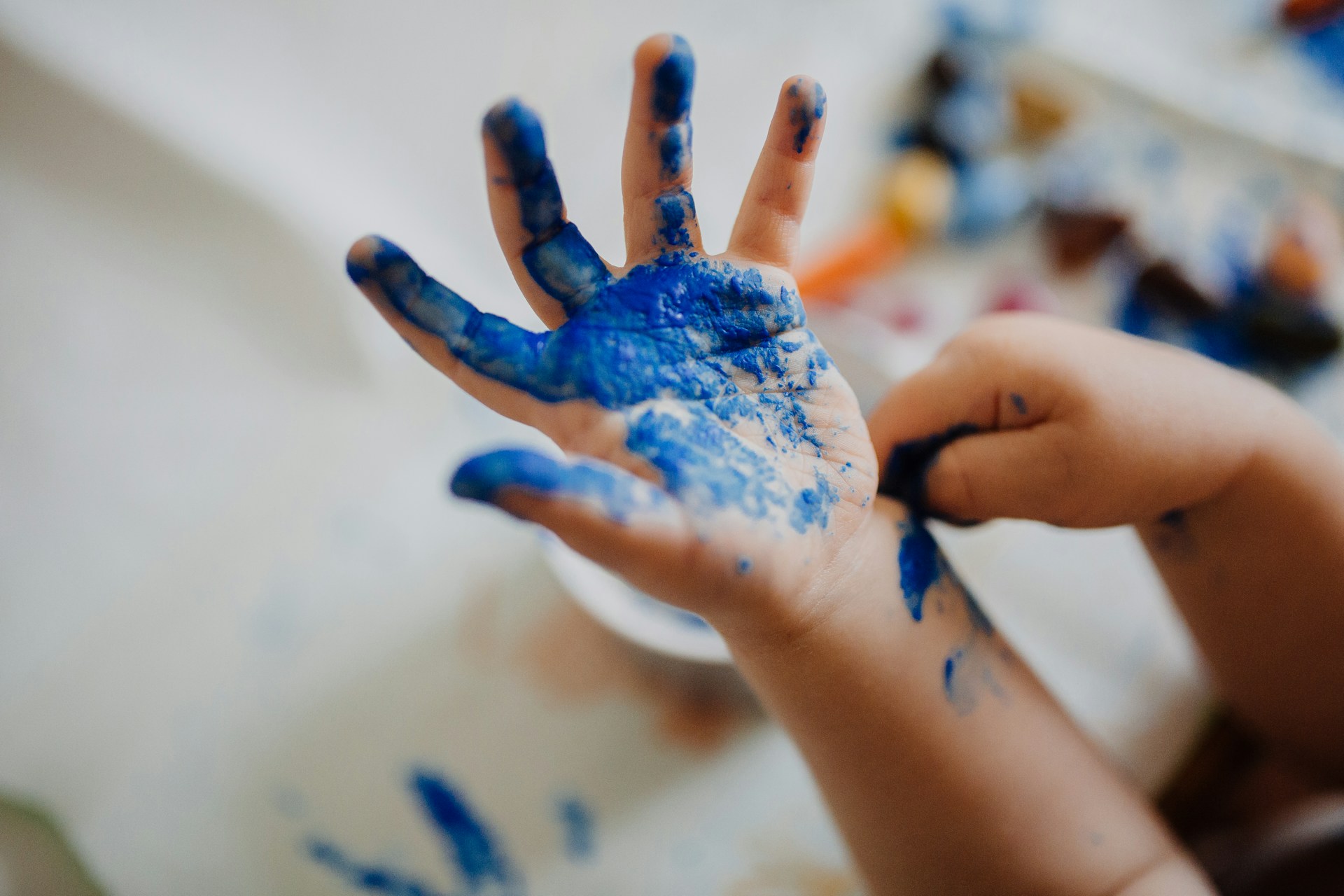 kid hand covered in blue paint