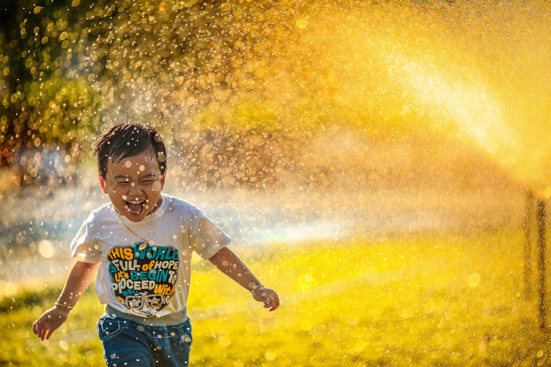 kid running through water spray