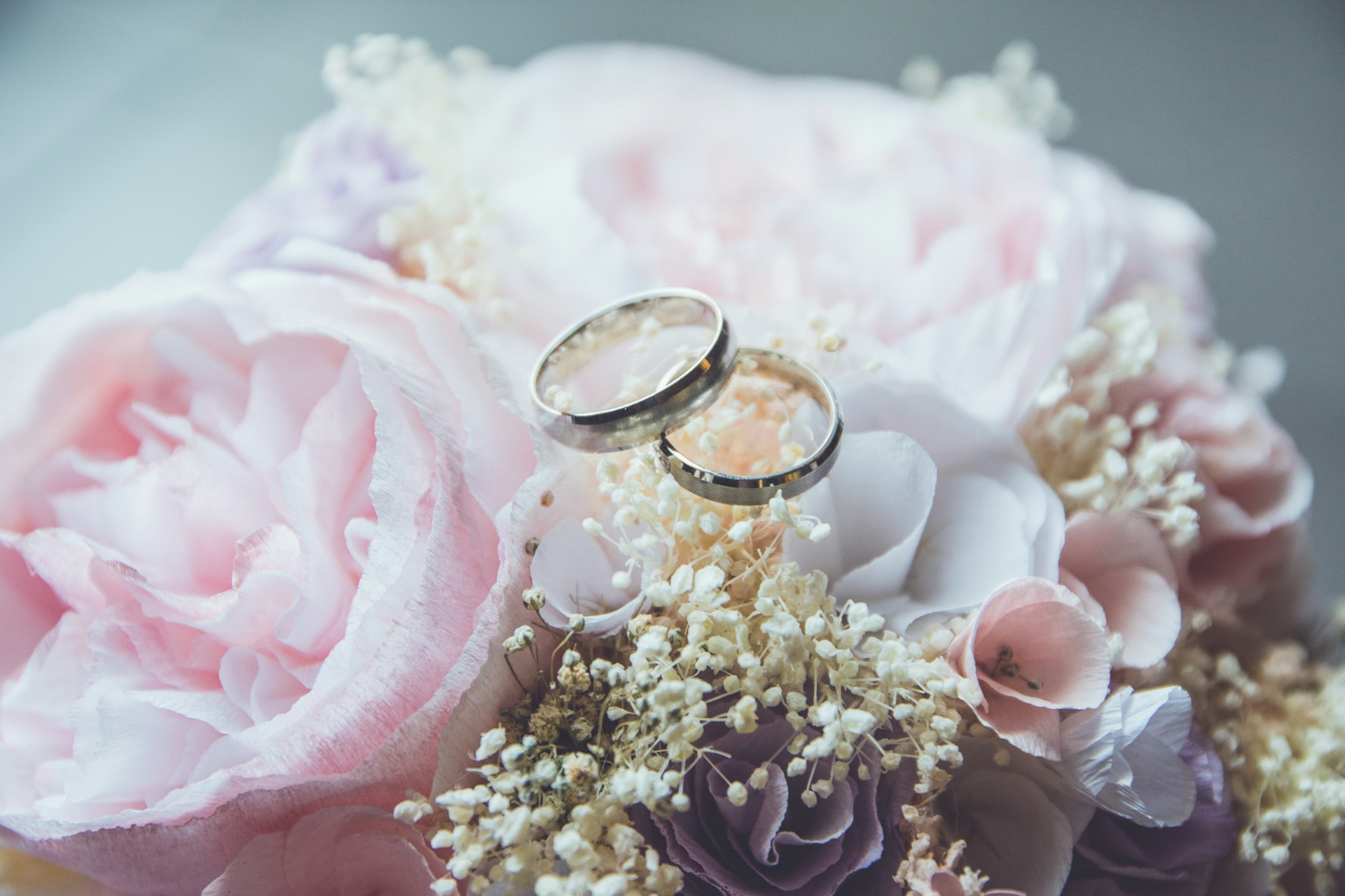 wedding bands on pink bouquet