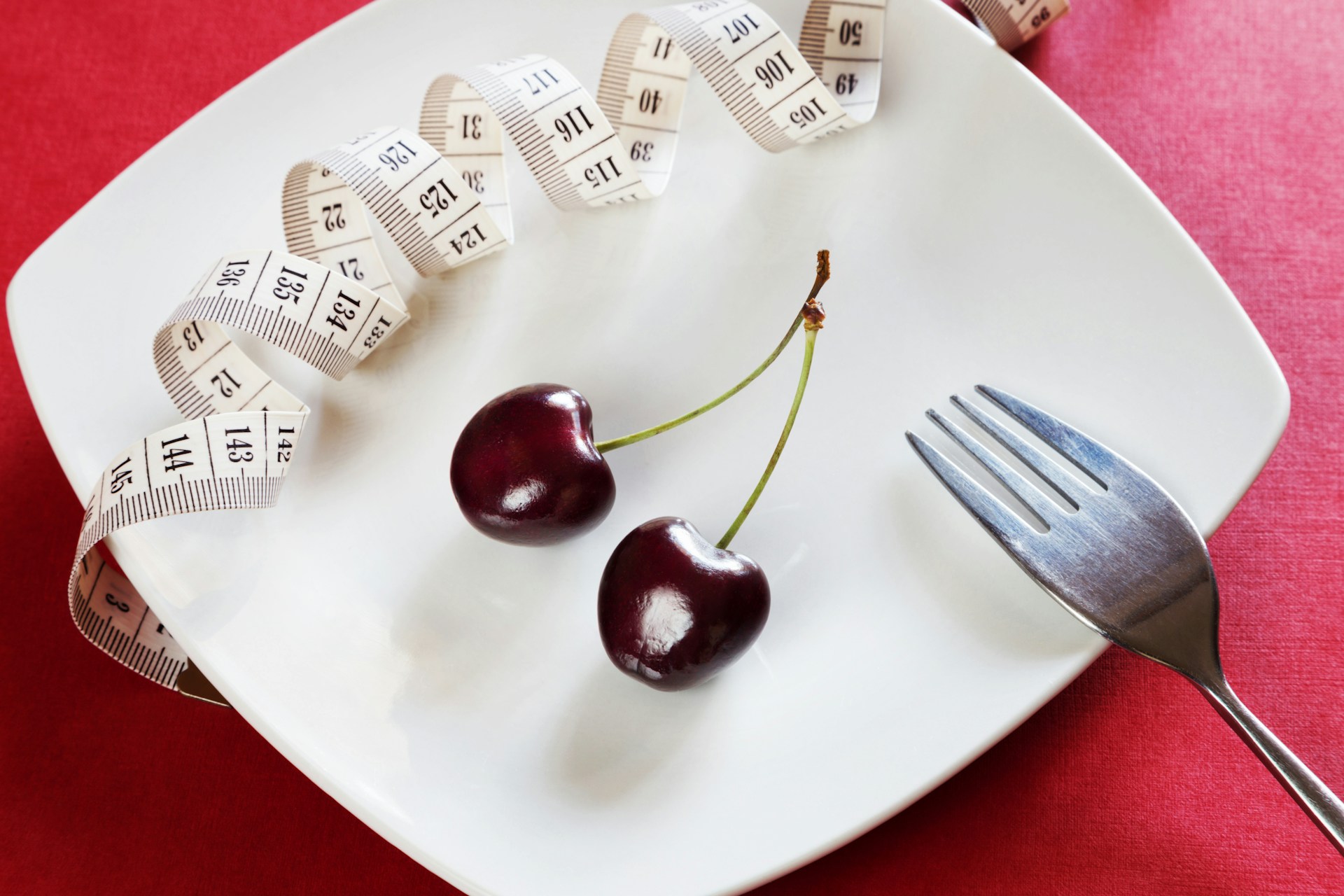 cherries on plate with measuring tape