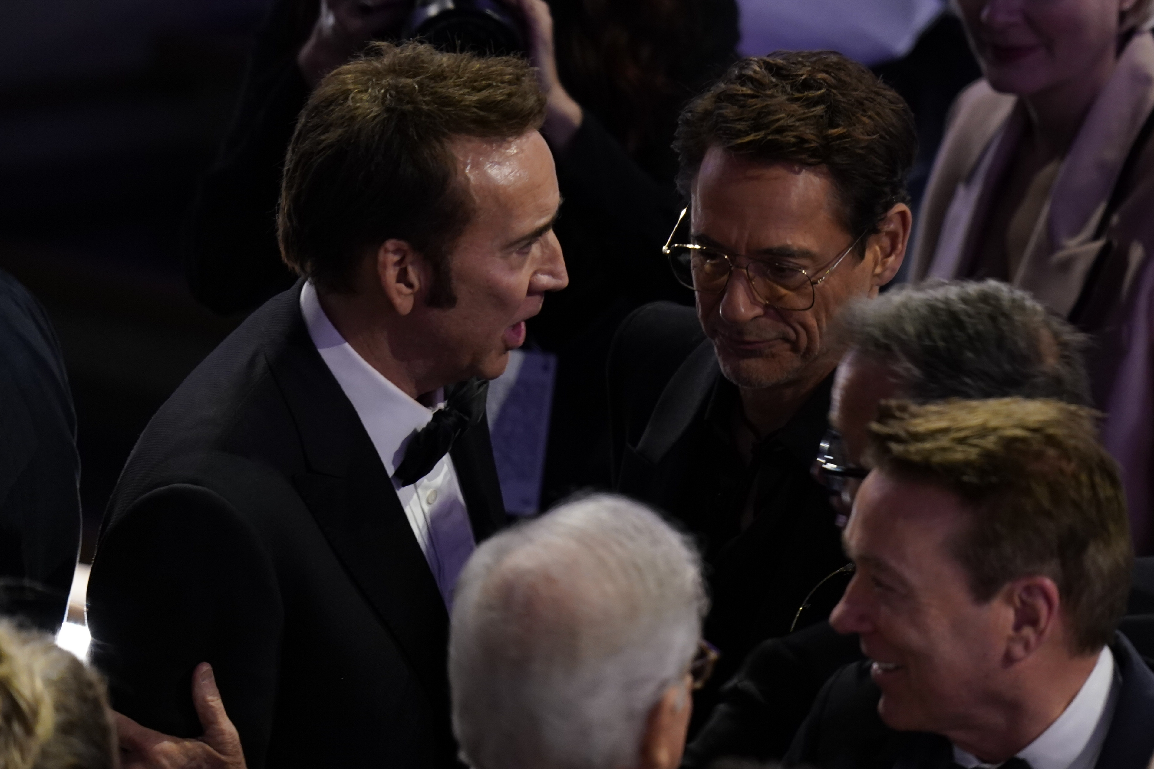 Mar 10, 2024; Los Angeles, CA, USA; Nicolas Cage, left, speaks with Robert Downey Jr. in the audience after Robert Downey Jr.’s