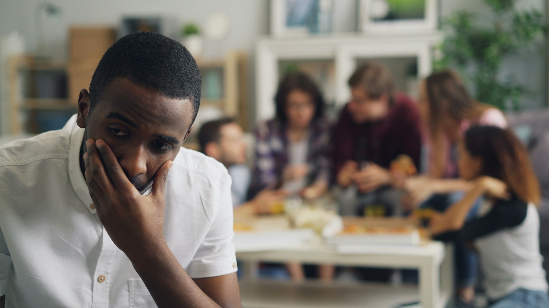 man sitting away from group of people