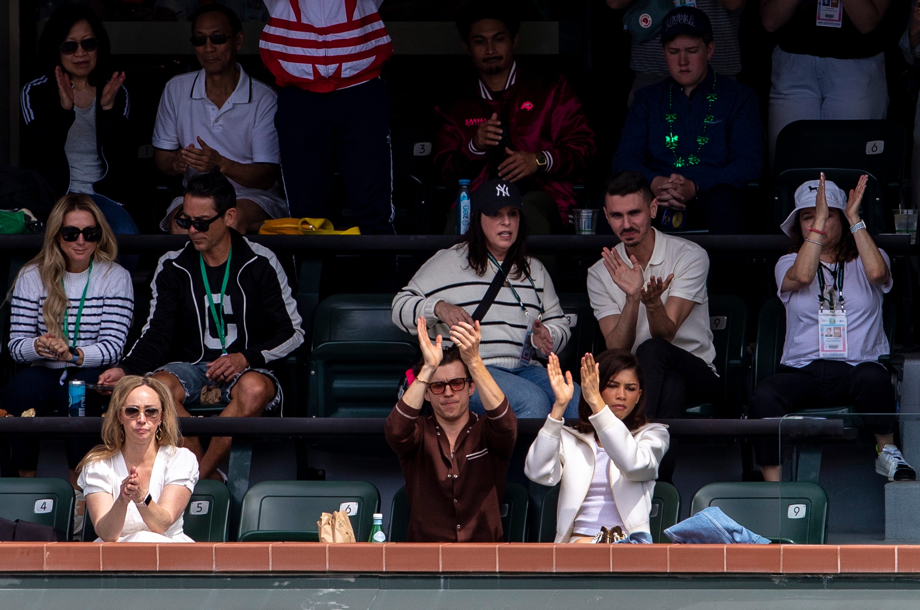 Actor Tom Holland and Actress and Singer Zendaya applaud Iga Swiatek as she's presented the championship trophy after winning