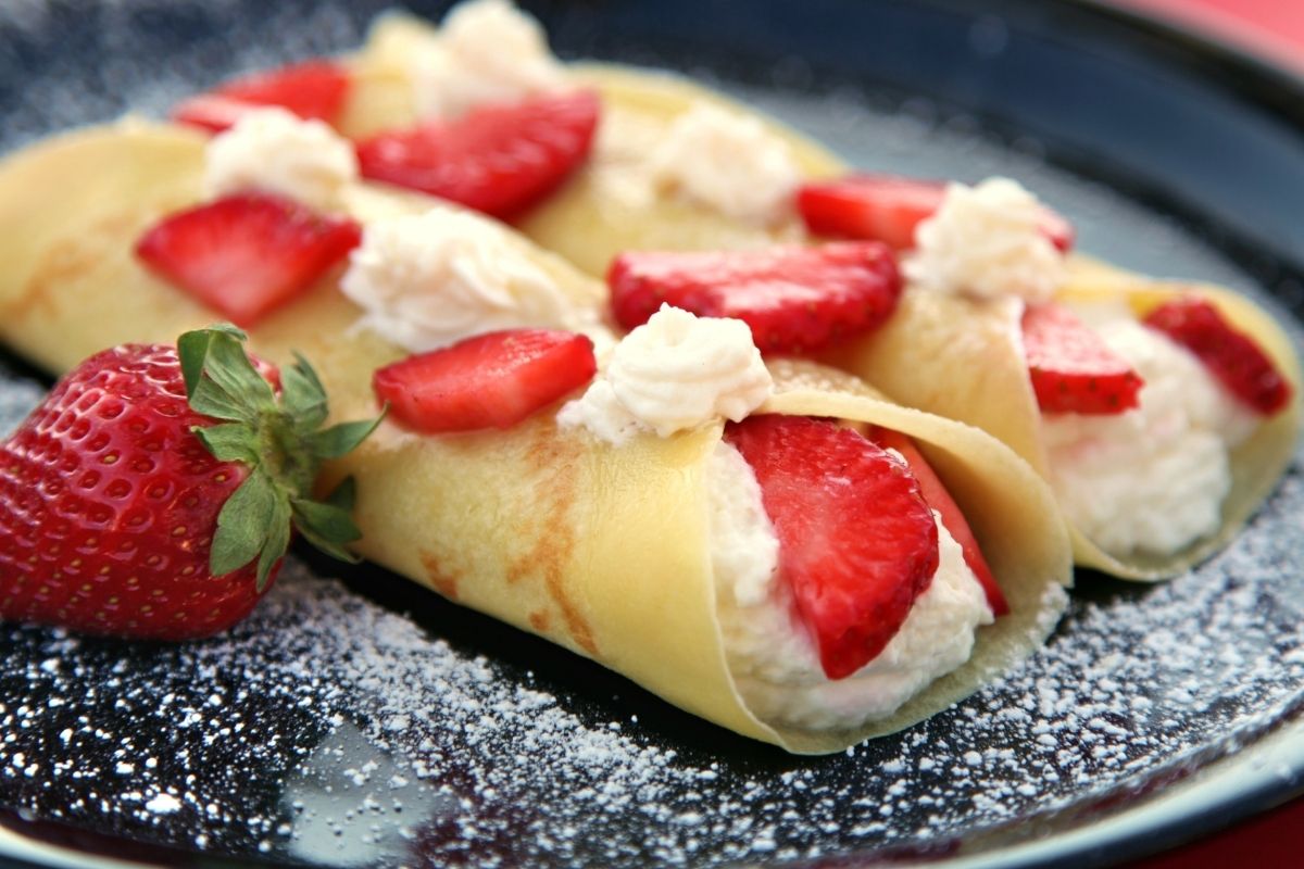 Two crepes filled with cream and strawberries.