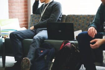 students with laptop on a couch