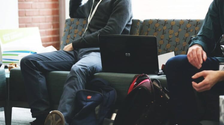 students with laptop on a couch