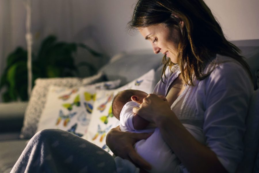 Young beautiful mother, breastfeeding her newborn baby boy at night ways to boost your milk supply