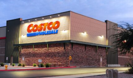 Costco Wholesale storefront with illuminated sign at dusk