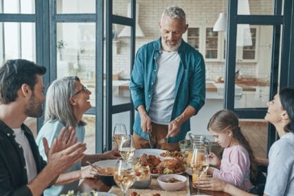 Multi-generational family gathered around dinner table sharing a meal together