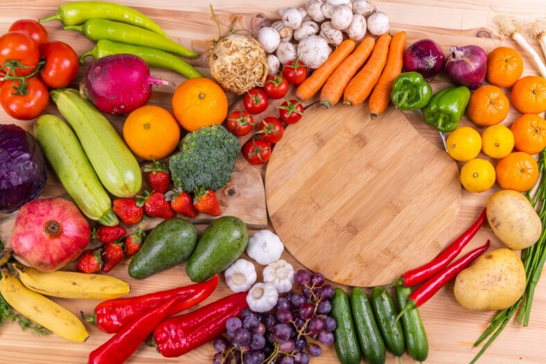 fruits and veggies next to cutting board