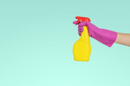 gloved hand holding spray bottle / spring cleaning products at costco