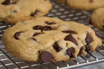 Fresh high altitude chewy soft chocolate chip cookies cooling on a wire rack.